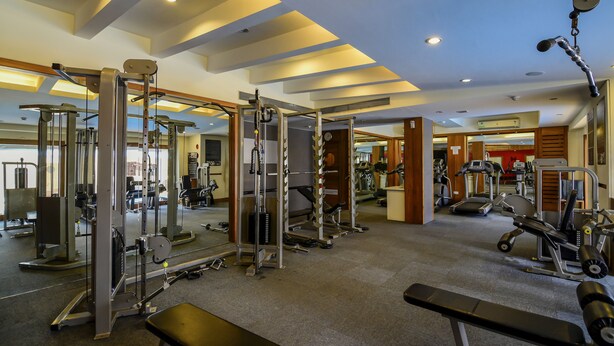 A gym with various exercise equipment, including weight machines and free weights.
