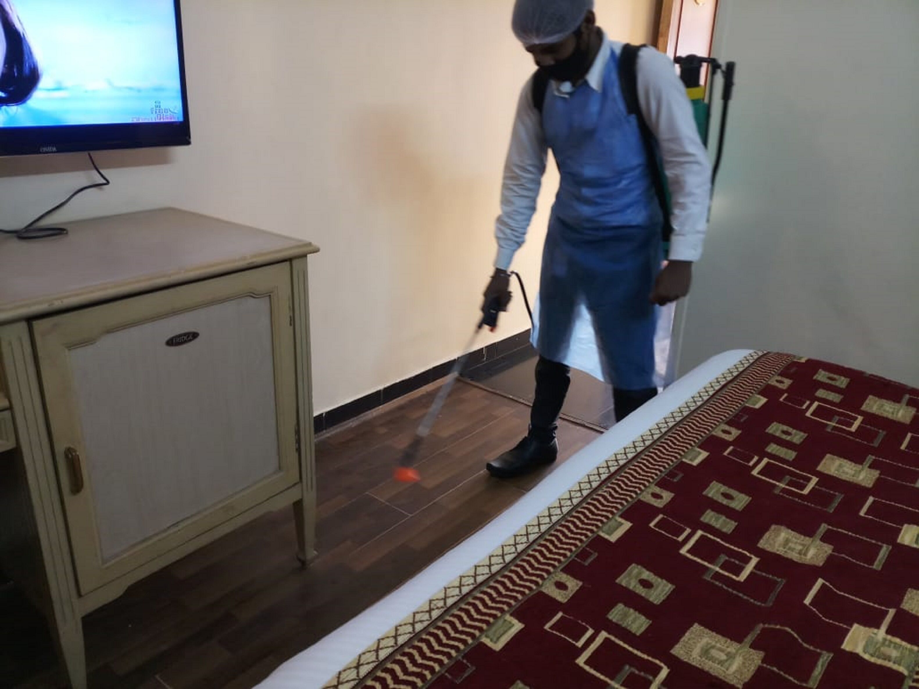 A person cleaning a room with a vacuum cleaner.