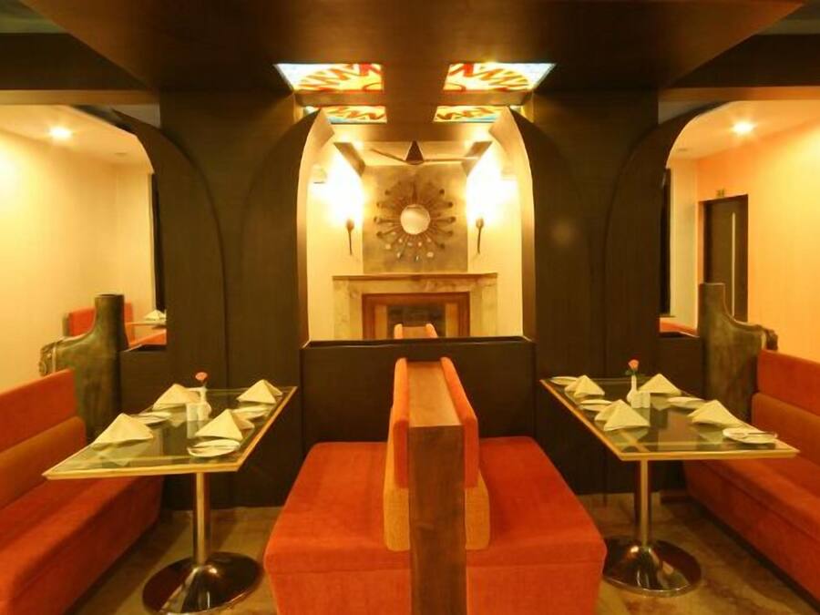 A restaurant with booths and tables, a fireplace, and decorative lighting.