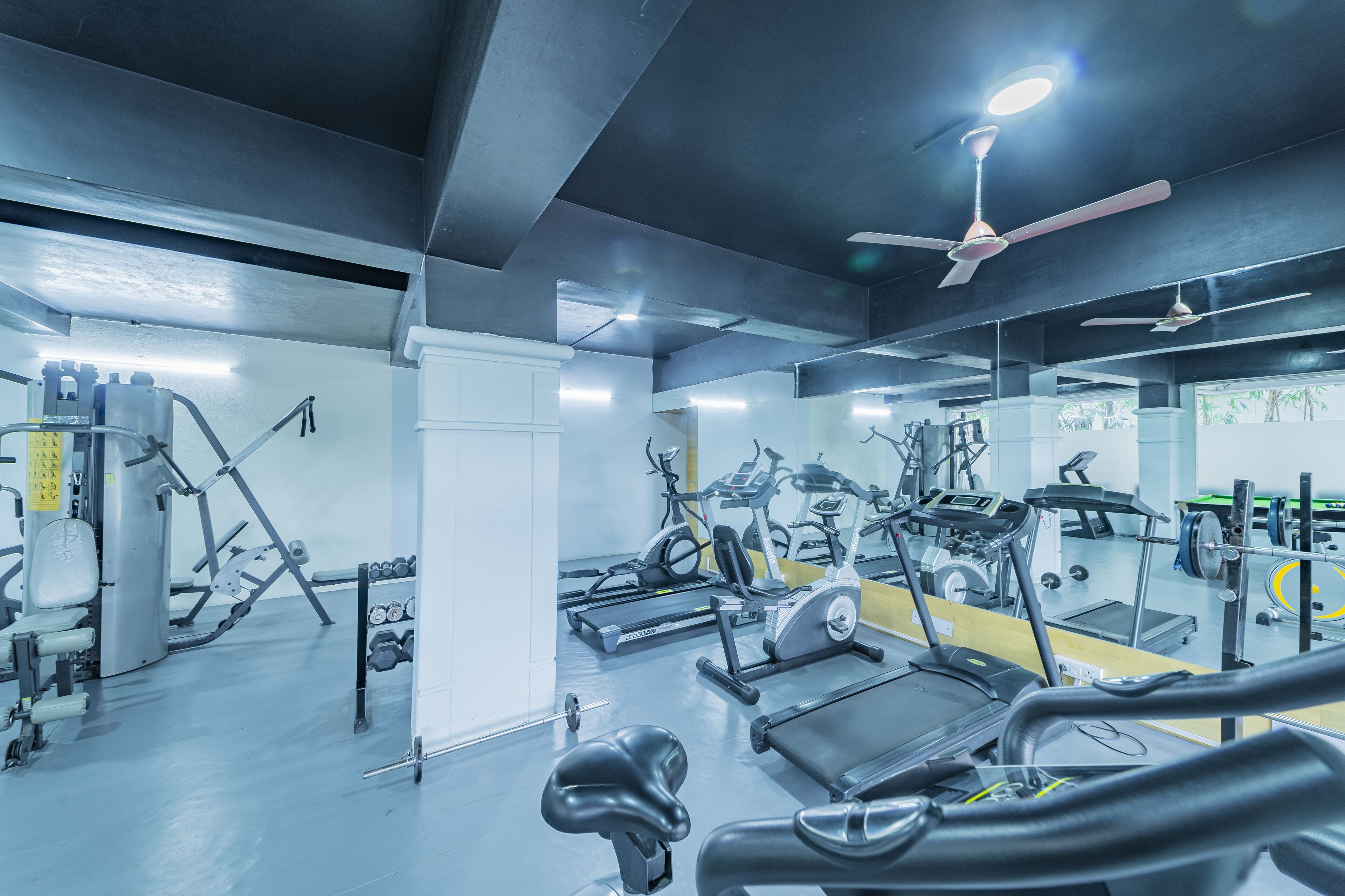 A gym with various exercise equipment, including treadmills and weight machines.