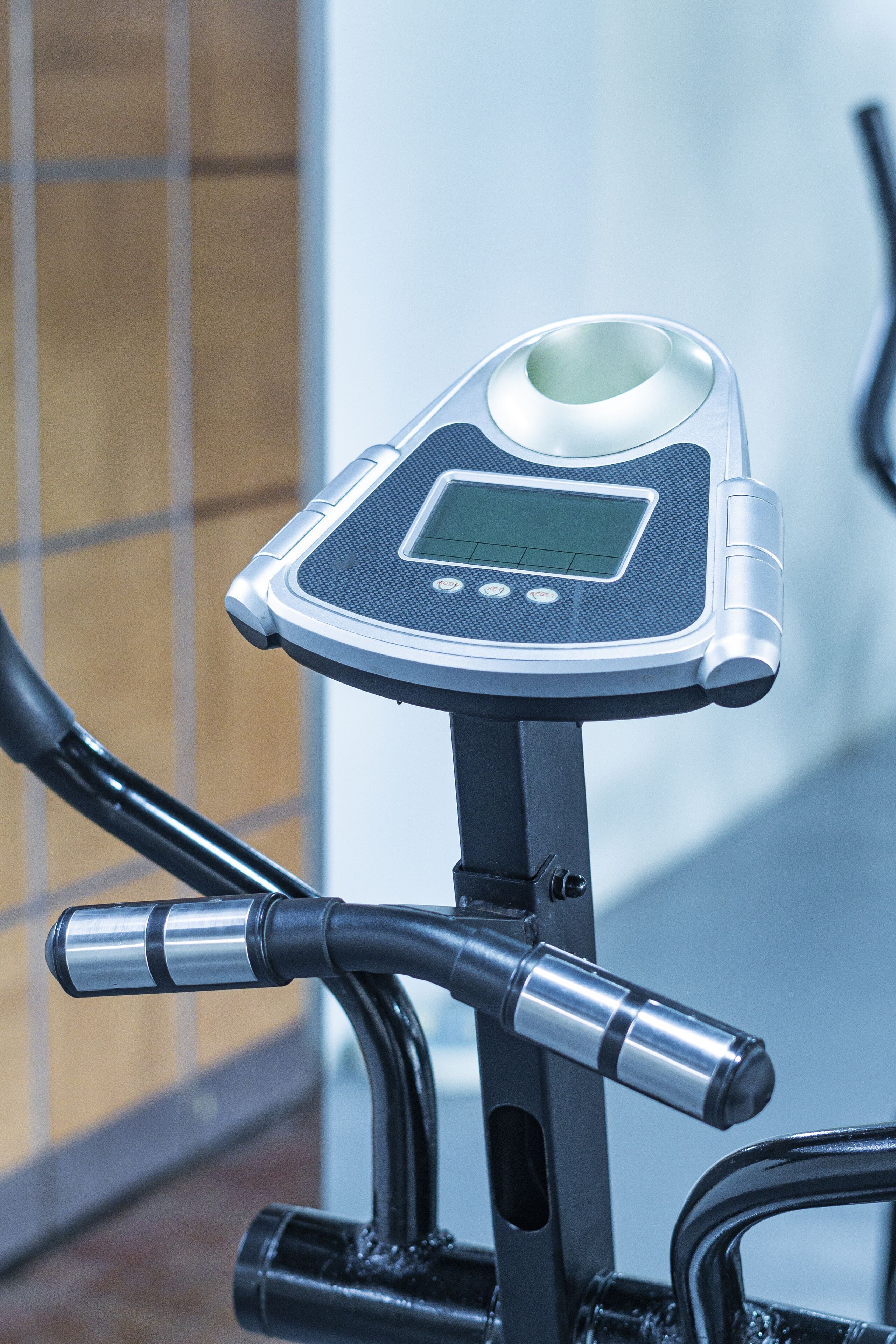 A stationary exercise bike with a digital display and handlebars.