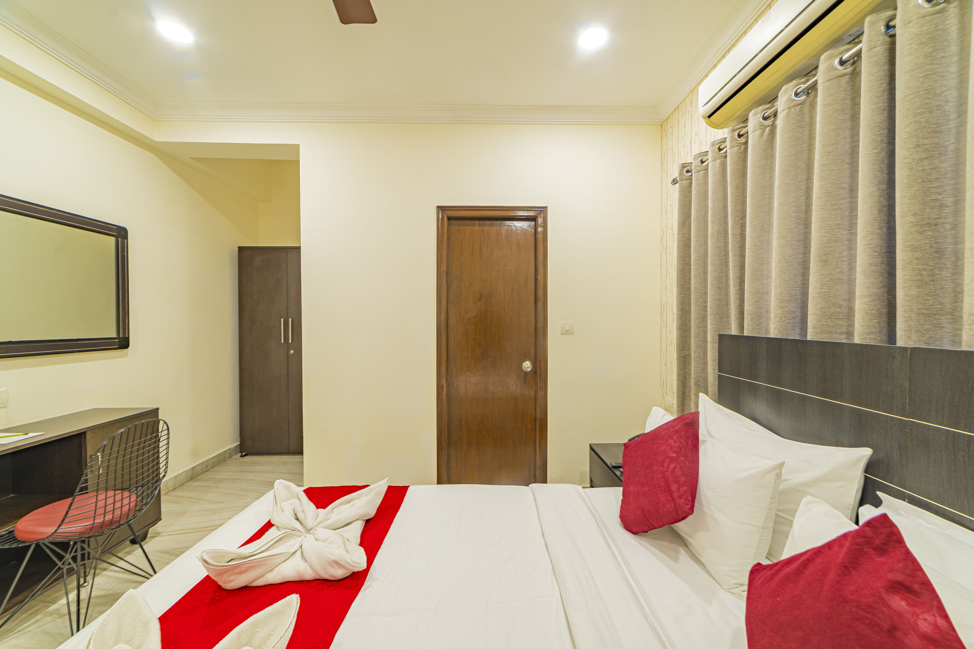 Une chambre d’hôtel comprenant un lit, un bureau, une chaise, une armoire et une salle de bain.