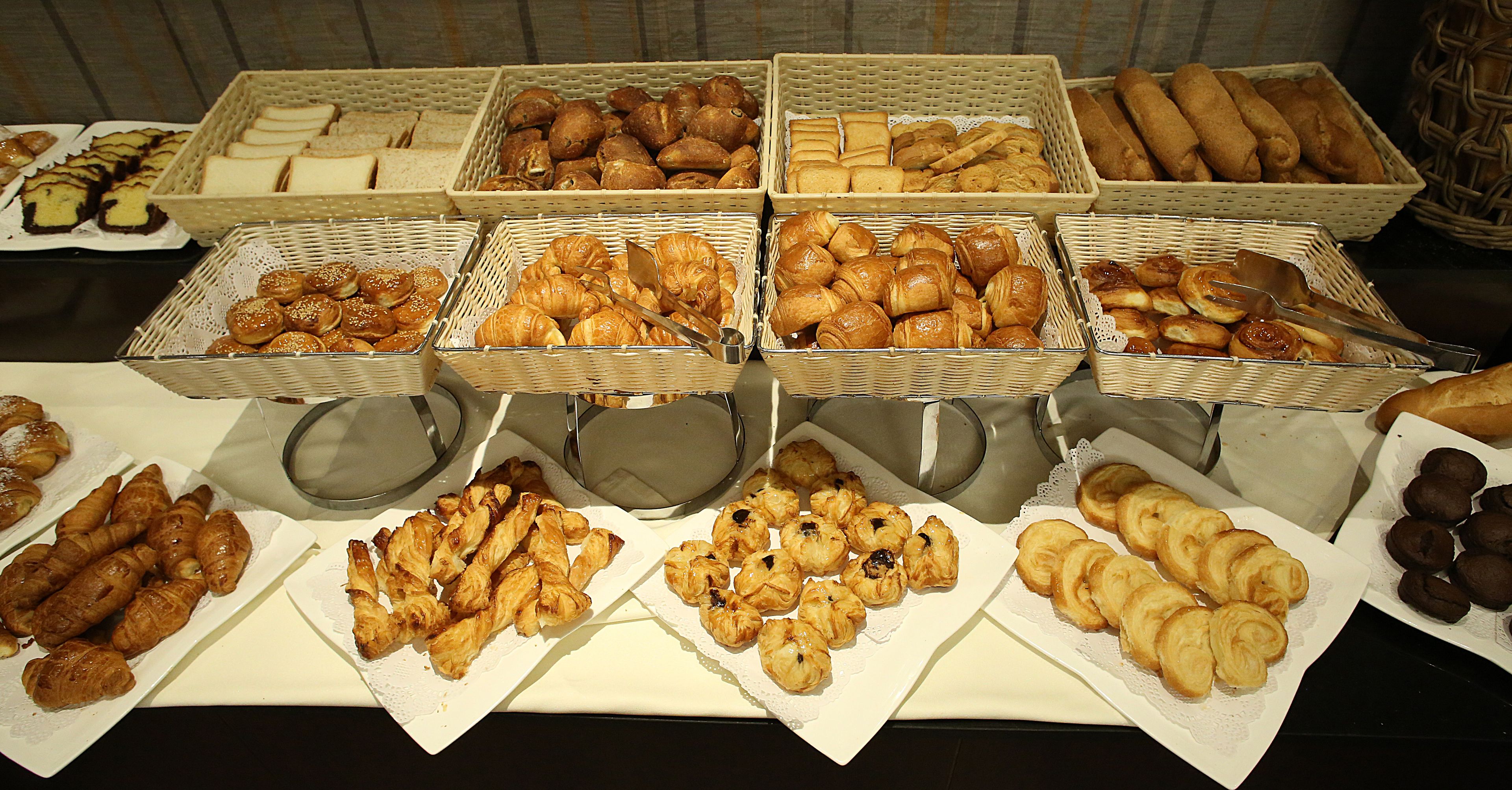 En buffetbod med forskellige bagværk, blandt andet brød, kager og croissanter.