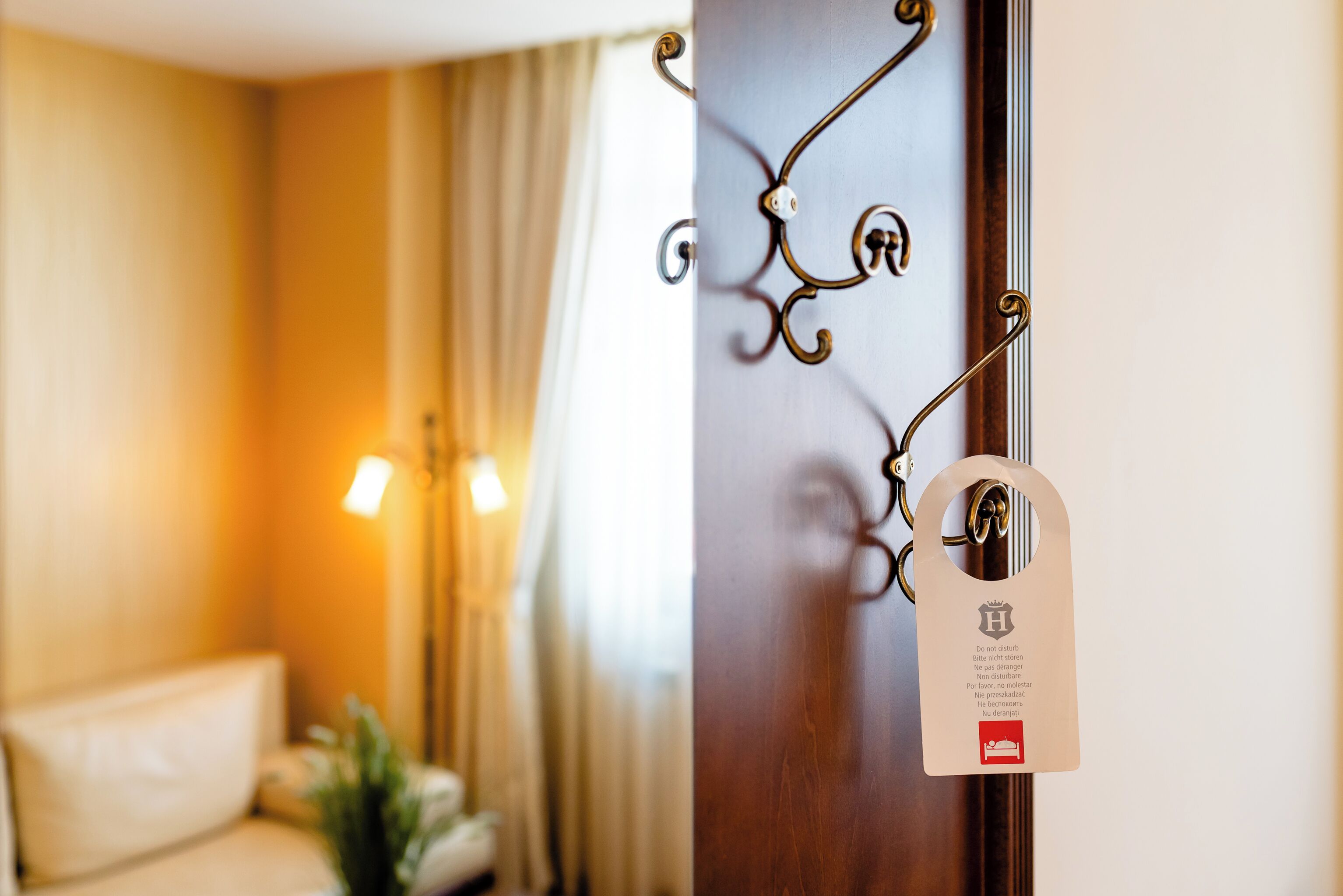 A hotel room with a wooden door, a metal handle, and a keycard with a hotel logo.