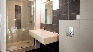 Une salle de bain moderne avec une douche à parois de verre, un lavabo avec un miroir et un porte-serviettes.