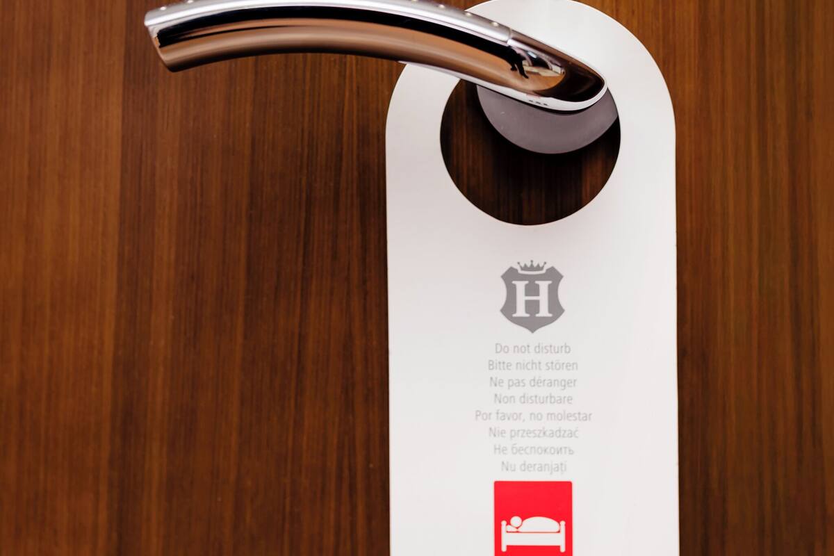 A metallic key inserted into a white keyhole with multilingual instructions and a red icon indicating a bed.
