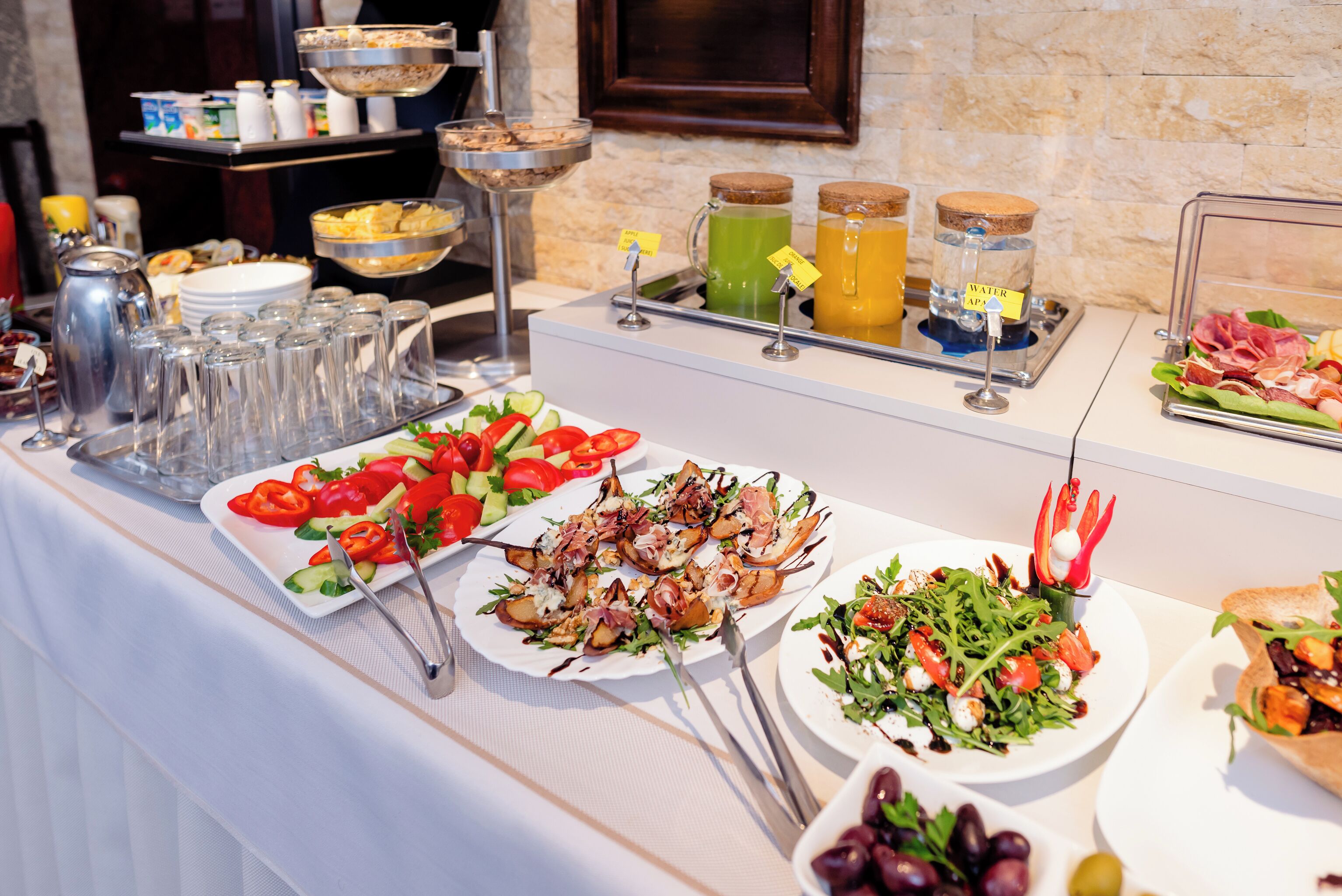 A buffet with various food options including salads, grilled items, and a selection of beverages.