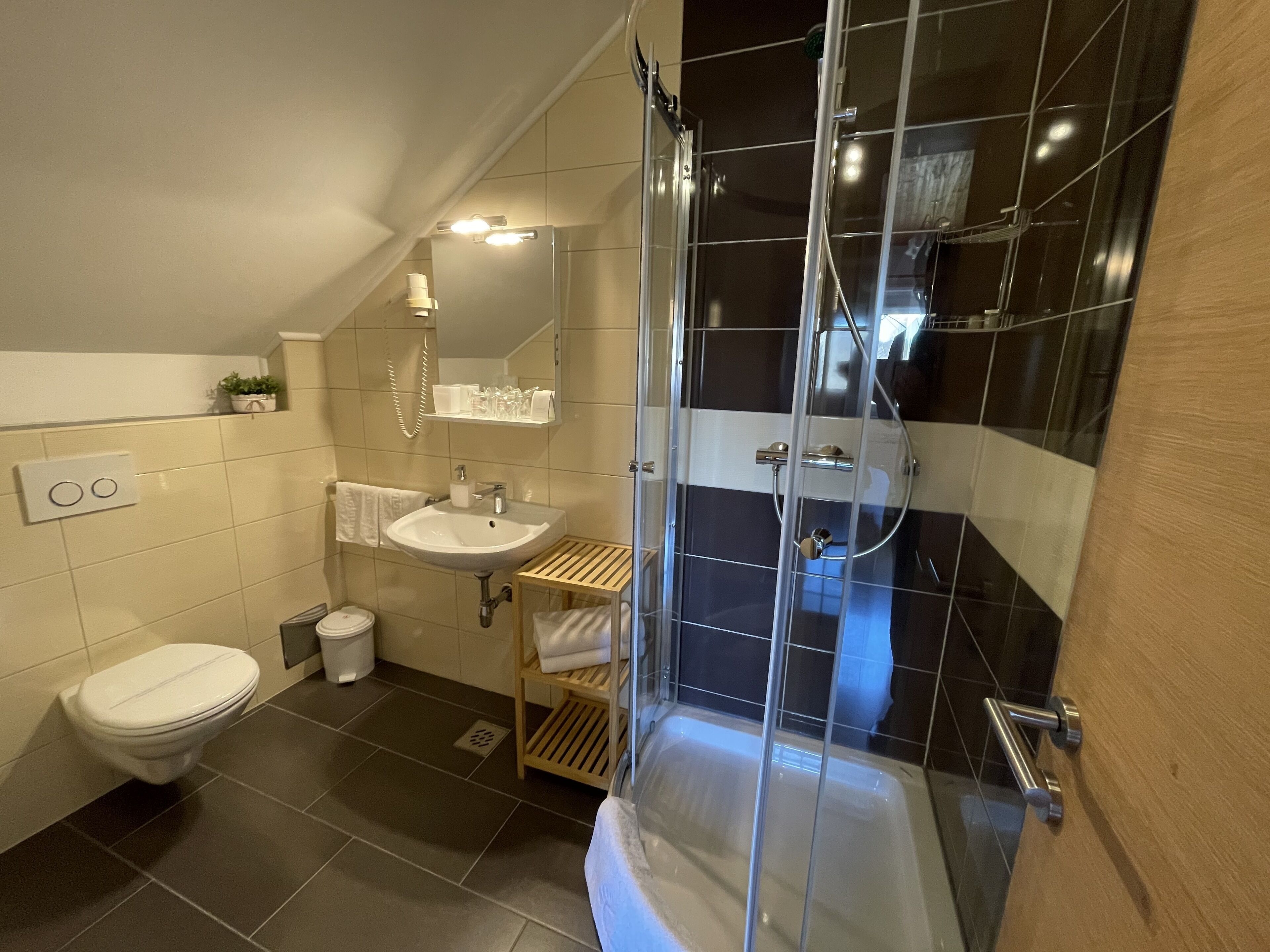Un baño moderno con cabina de ducha de vidrio, lavamanos y retrete.