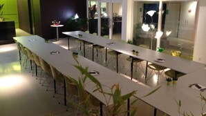 A modern conference room with long tables and chairs, equipped with small potted plants. - Corbie Geel (Geel)