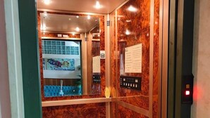 Un ascensor con paredes de mármol y un panel de control.