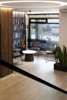 A modern interior with a wooden accent wall, a round coffee table, and a seating area with chairs.