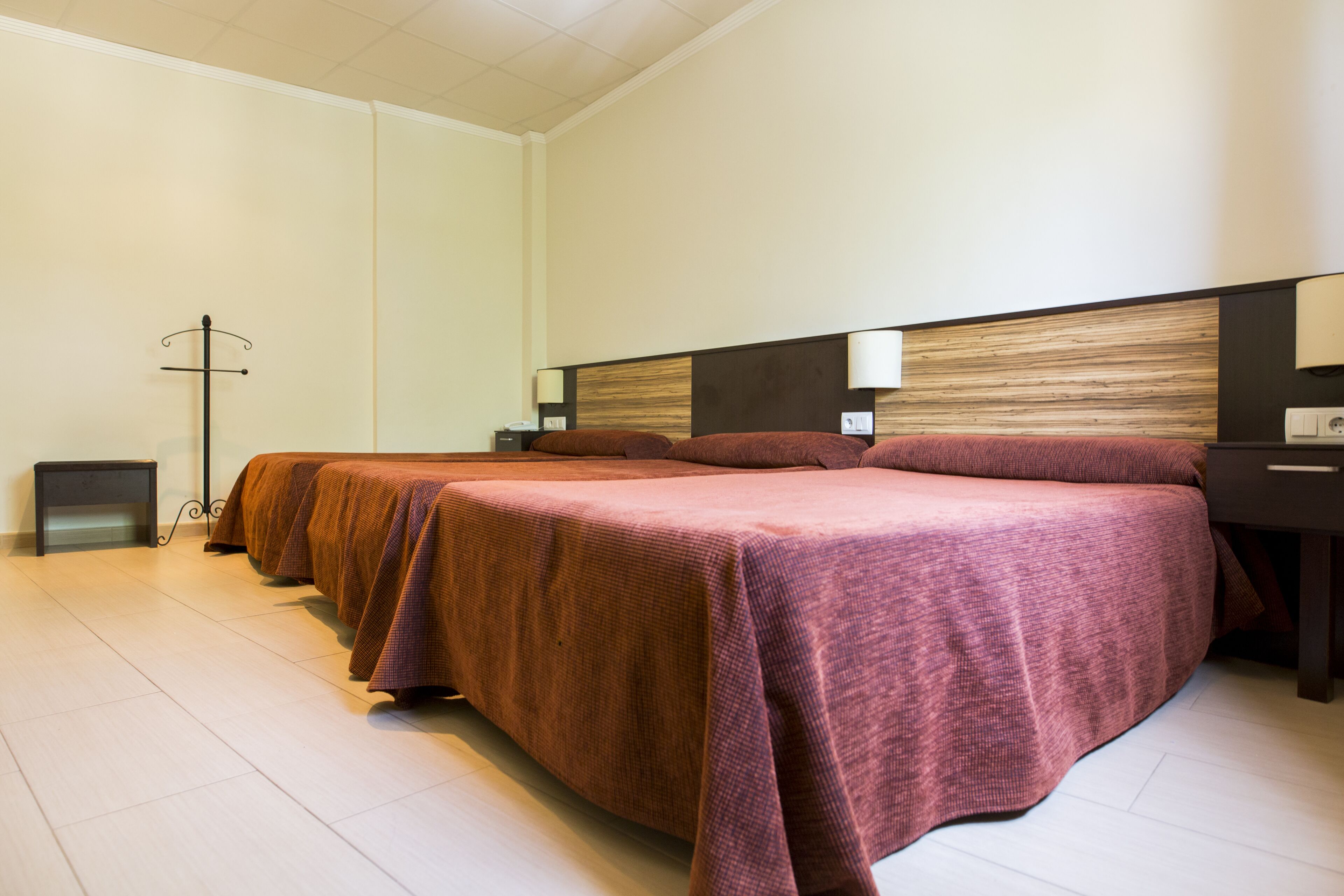 Une chambre d’hôtel avec deux lits, une table de chevet, une lampe de chevet et une lampe sur pied.