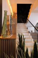 A staircase with a wooden railing and a series of glass vases on a wooden platform.