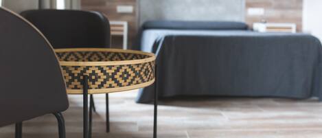 A modern hotel room with a bed, a chair, and a small table.