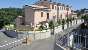 Un edificio de varios pisos con una escalera central y una entrada con reja.