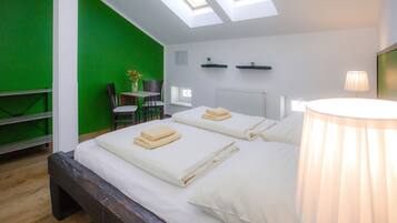 A room with a bed, skylights, a desk, and a chair.