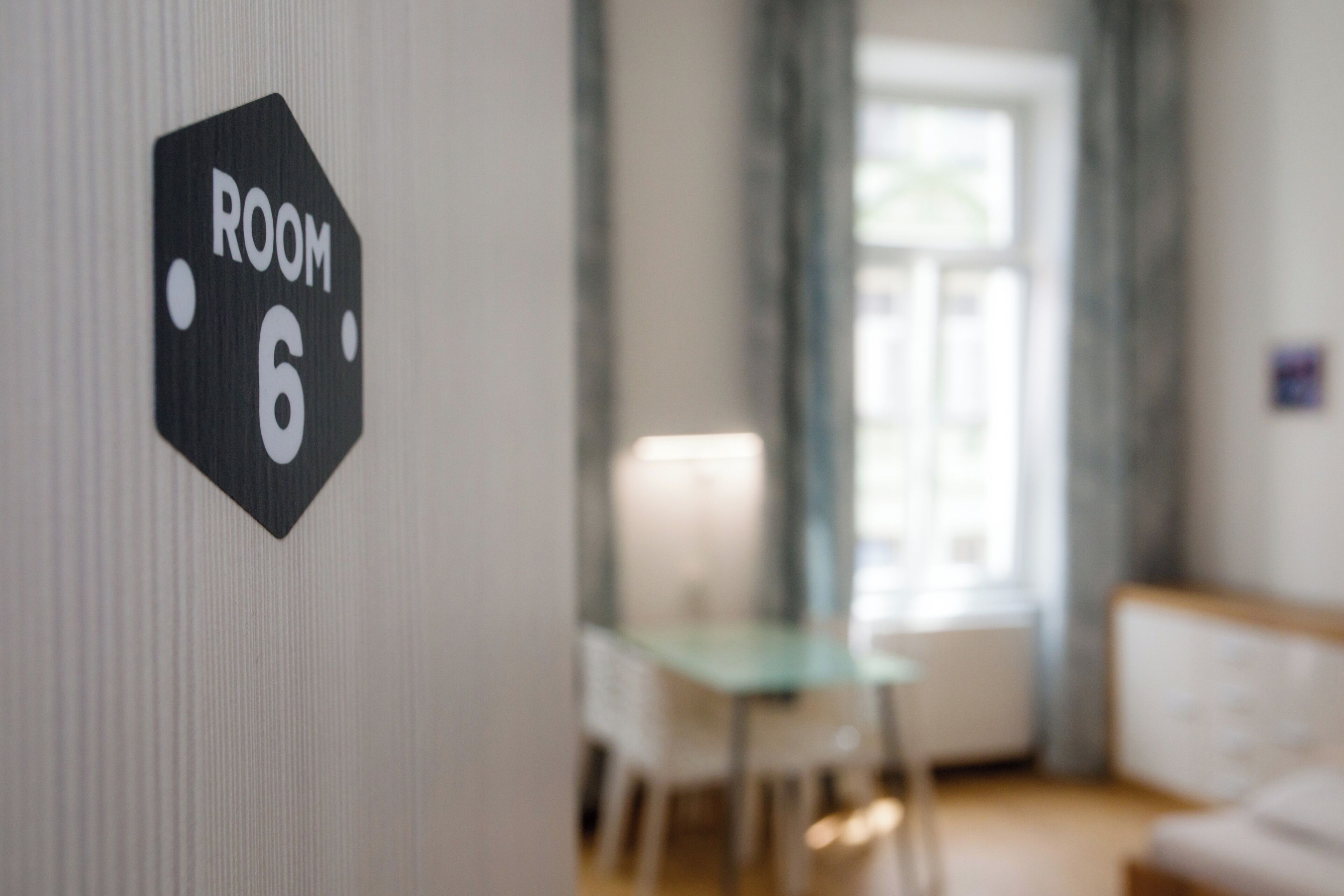 A sign indicating 'ROOM 6' on a wall.