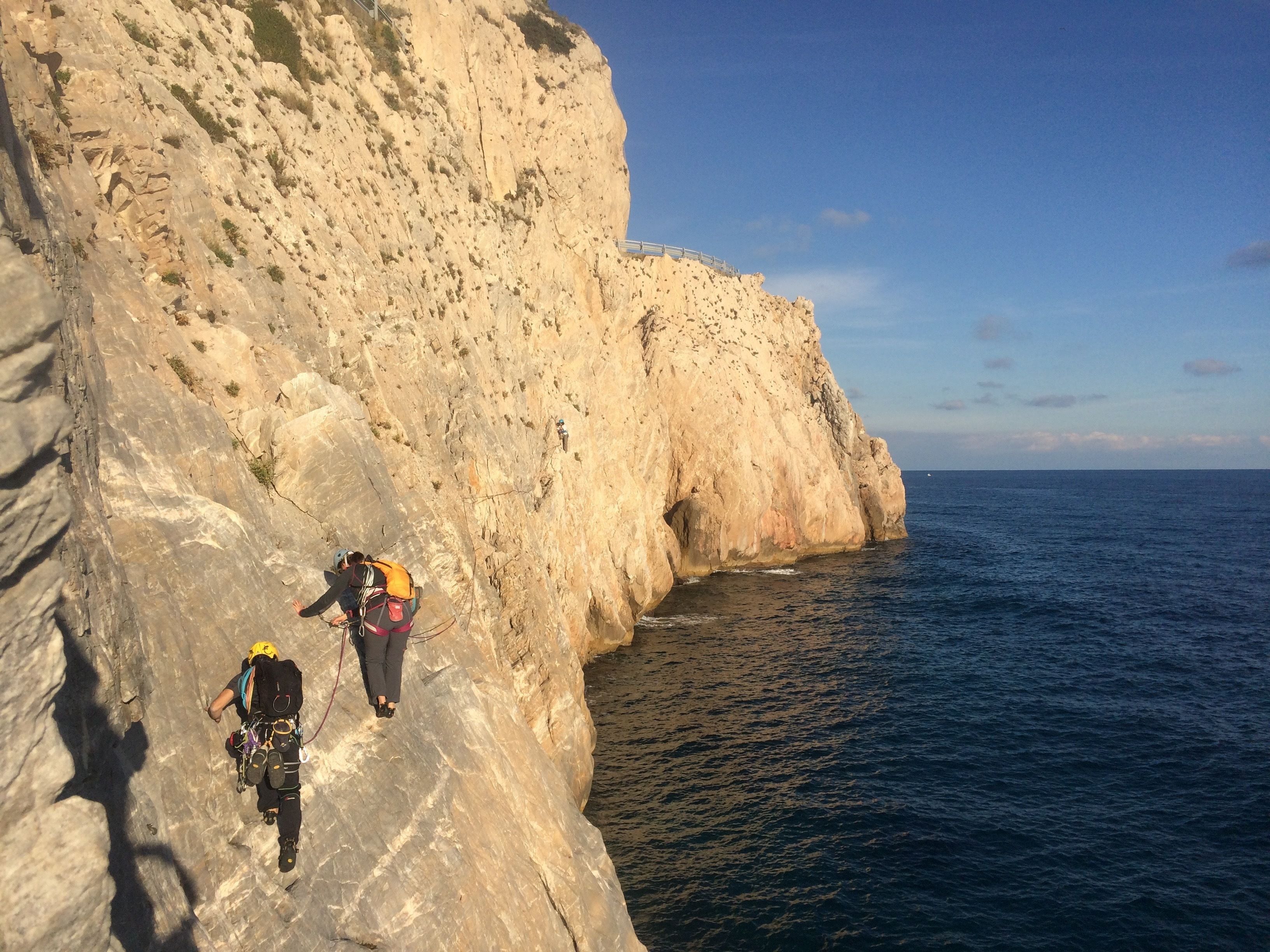 Une côte rocheuse avec un sentier étroit qui descend vers la mer.