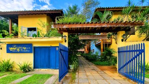 Un sendero lleva a un edificio con una puerta azul y un cartel que dice "Ramo dos Ventos".