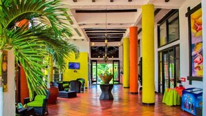 A hotel lobby with a checkered floor, a central plant, and seating areas. - Sansiraka (Santa Marta)