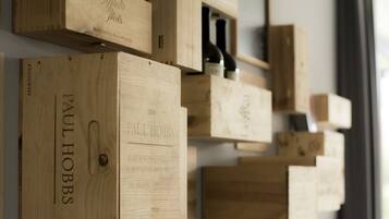 Cajas de madera para vino con nombres y añadas, dispuestas en una pared.