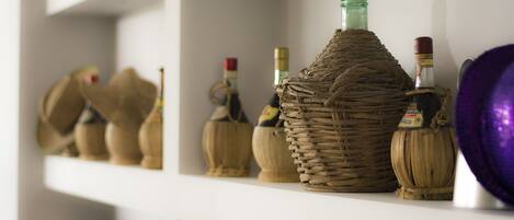 Una estantería con diversos frascos y recipientes, incluyendo una cesta de mimbre y un cuenco morado.
