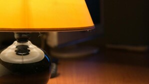 A table lamp with a yellow shade on a wooden surface. - Auberge le XIXème (Hensies)