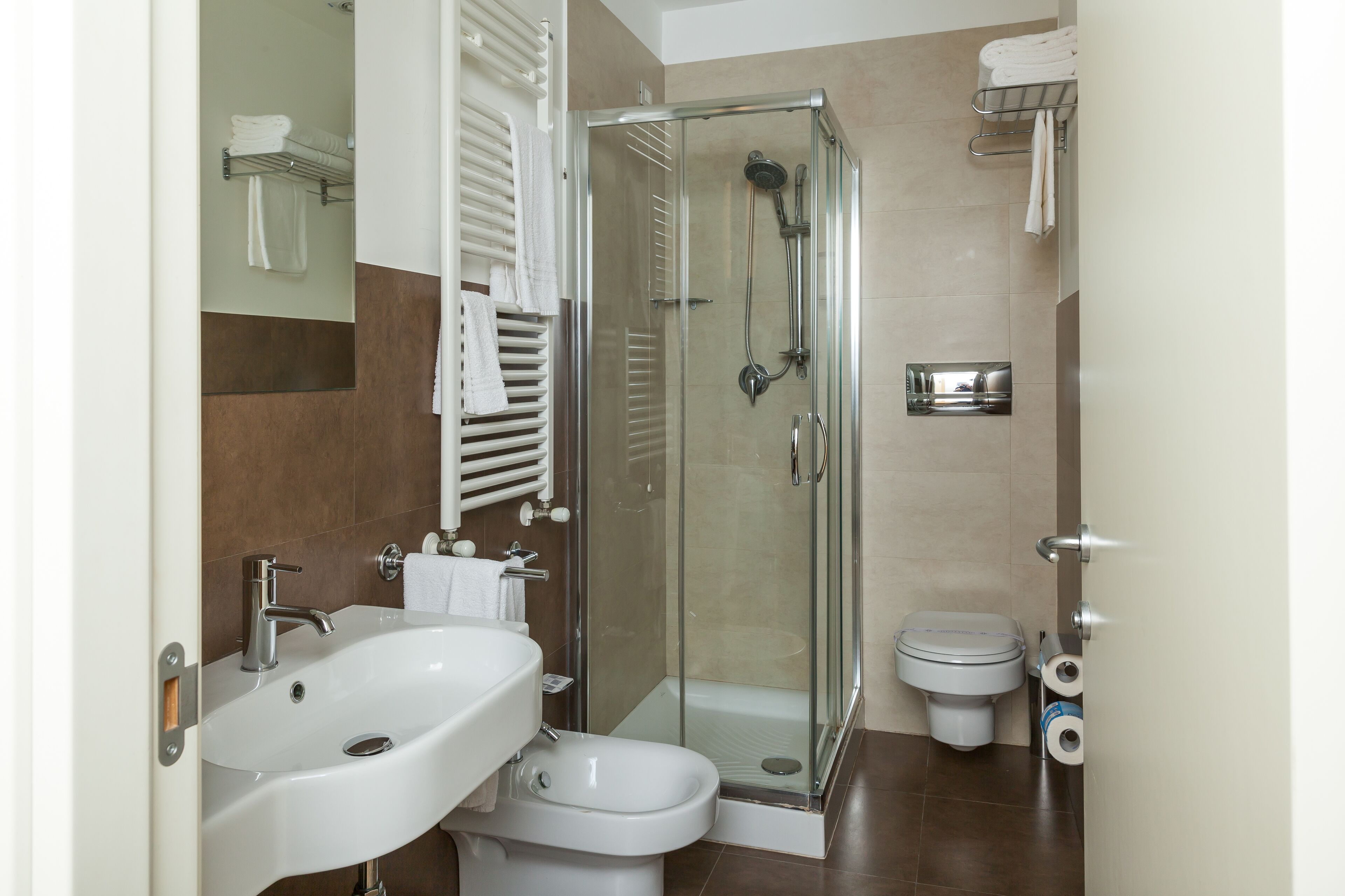 A modern bathroom with a glass-enclosed shower, a white sink, and a toilet.