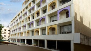 Un hôtel à plusieurs étages, doté d’une façade symétrique et de balcons à chaque niveau.
