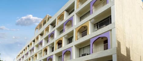 Un hotel de varios pisos con una fachada simétrica, que cuenta con balcones en cada planta.