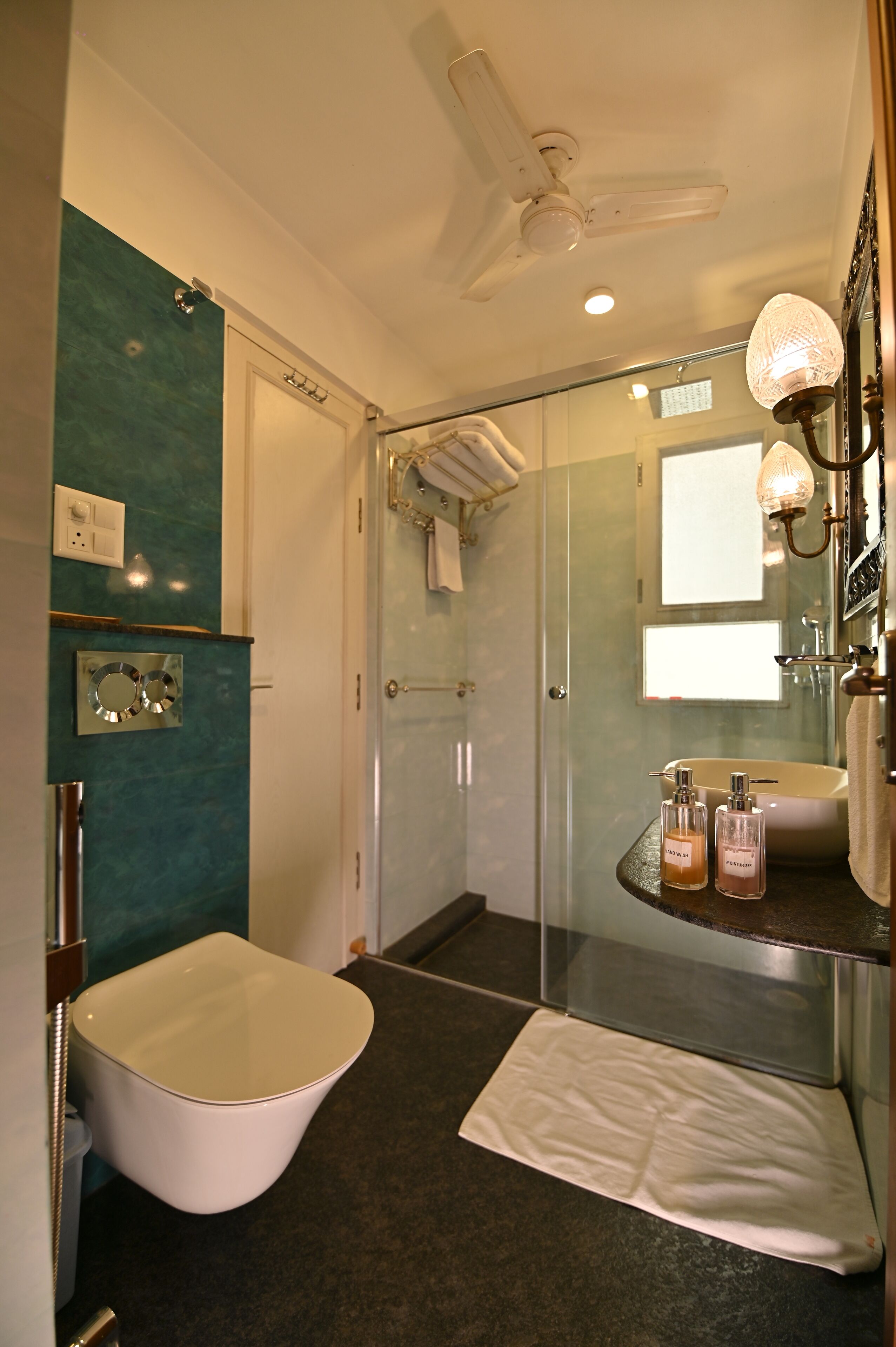A modern bathroom with a freestanding bathtub, a glass shower enclosure, and a vanity with a mirror and light fixture.