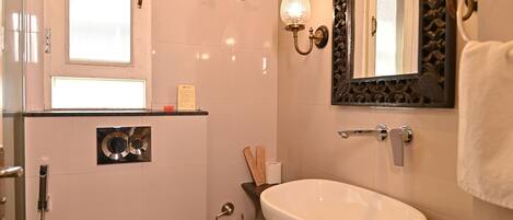 A modern bathroom with a toilet, sink, and shower.