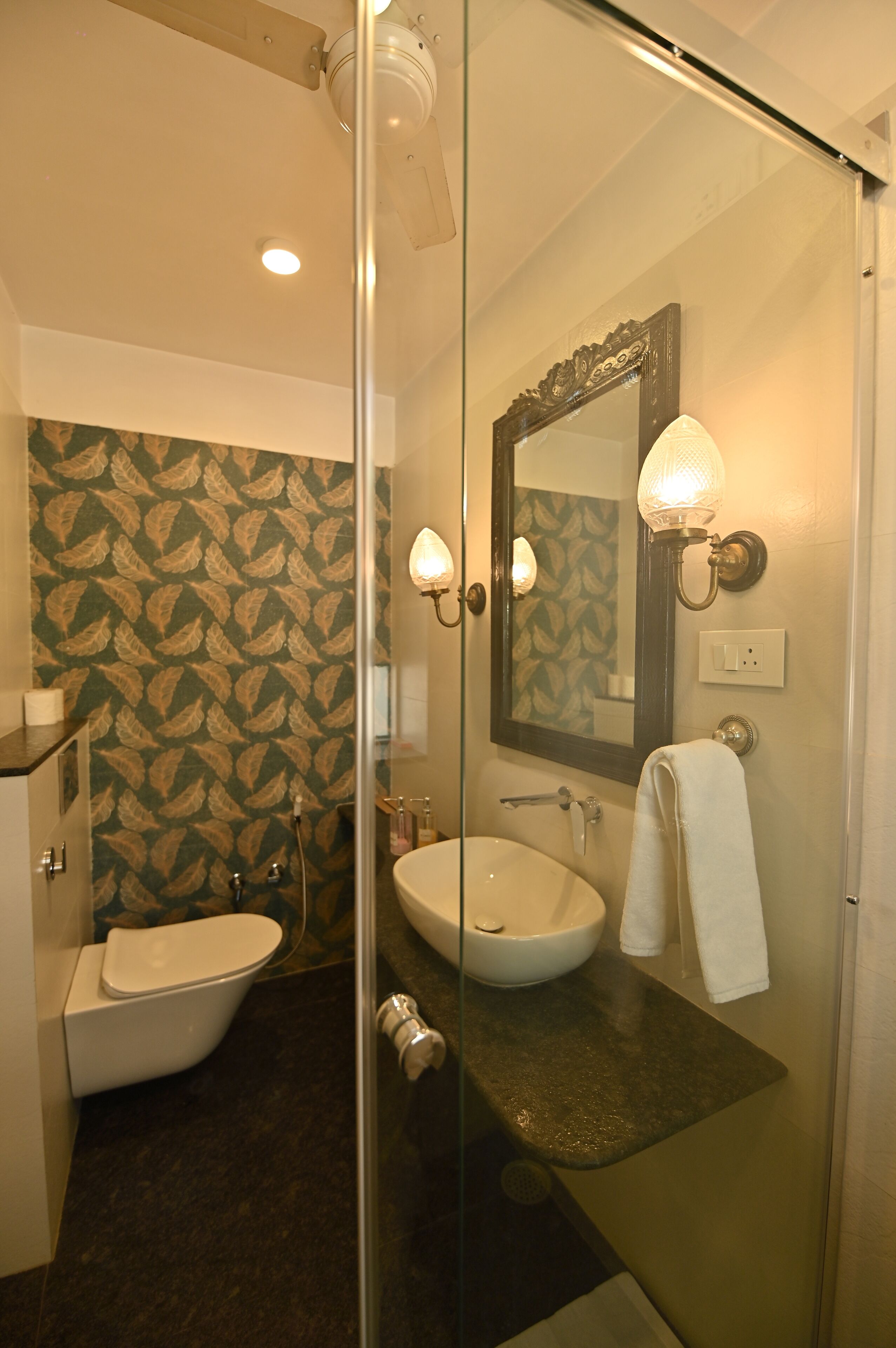 A bathroom with a glass shower enclosure, a bathtub, and a sink with a mirror above it.