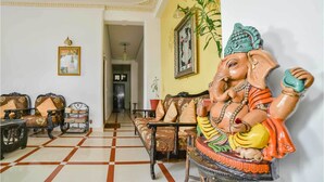 Una sala de estar con sofá, sillas, una mesa y una estatua de elefante.