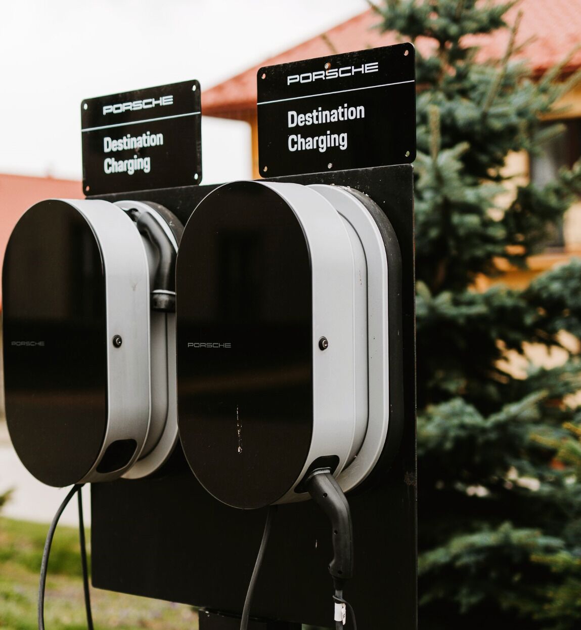 Two Porsche destination charging stations with signs indicating their purpose.