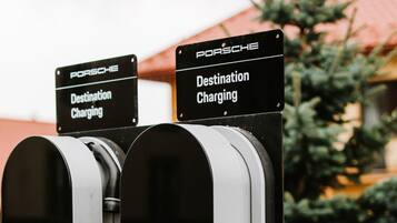Two Porsche destination charging stations with signs indicating their purpose.