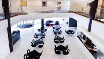 Un hall d’entrée spacieux avec un espace salon central, un escalier et une mezzanine.