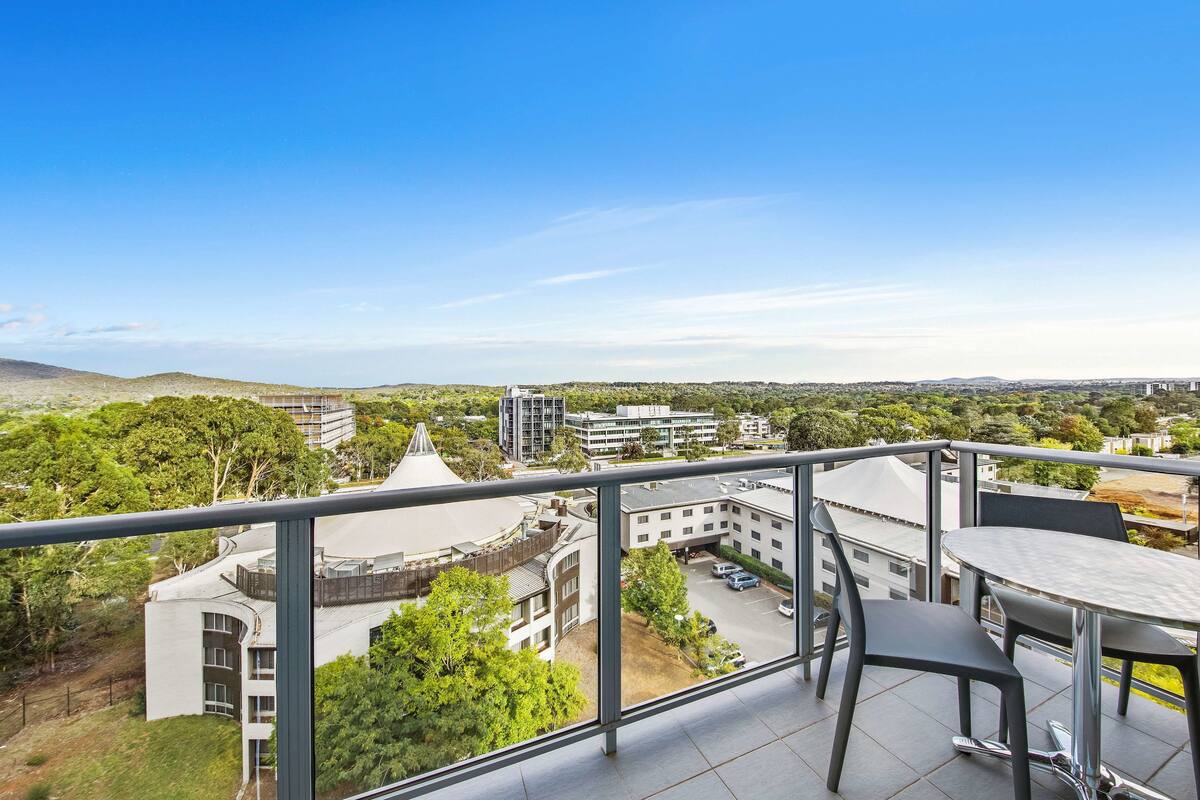 Ein Balkon mit Blick auf einen Stadtblick, einschließlich Gebäude und Grünflächen.