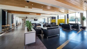 A spacious lobby with a modern design, featuring a reception desk, seating areas, and large windows providing natural light. - Residences Université Laval - Campus Accommodation (Québec City)