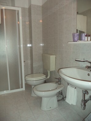 A bathroom with two toilets, a sink, and a shower. - Hotel Il Nibbio (Magreglio)