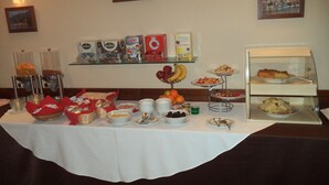 Una mesa de buffet con diversos alimentos y una estación de café.