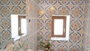 Een badkamer met een vrijstaand bad, een wastafel en twee spiegels aan de muur.