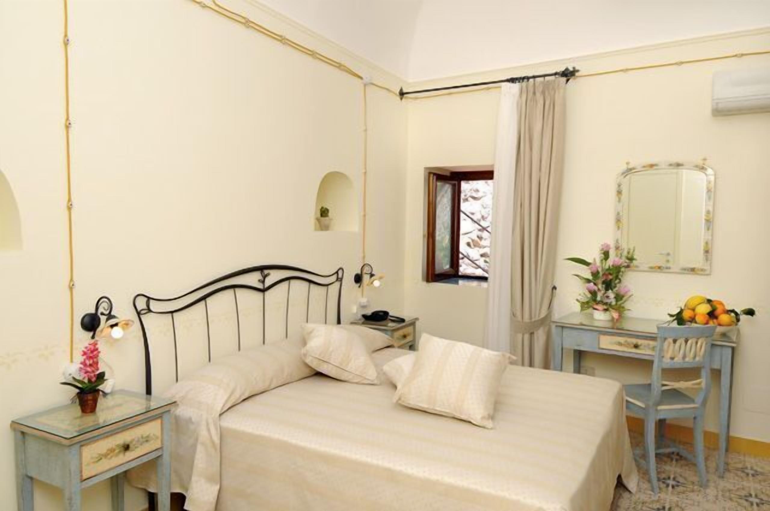 Une chambre à coucher comprenant un lit, une table de chevet, une chaise et un bureau avec un miroir.