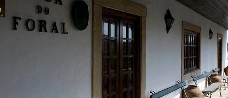 A building with a sign reading "CASA DO FORAL" and a wooden door. There are benches along the side.