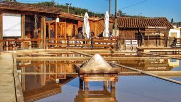 A wooden building with a tiled roof, a wooden fence, and a reflection pool.