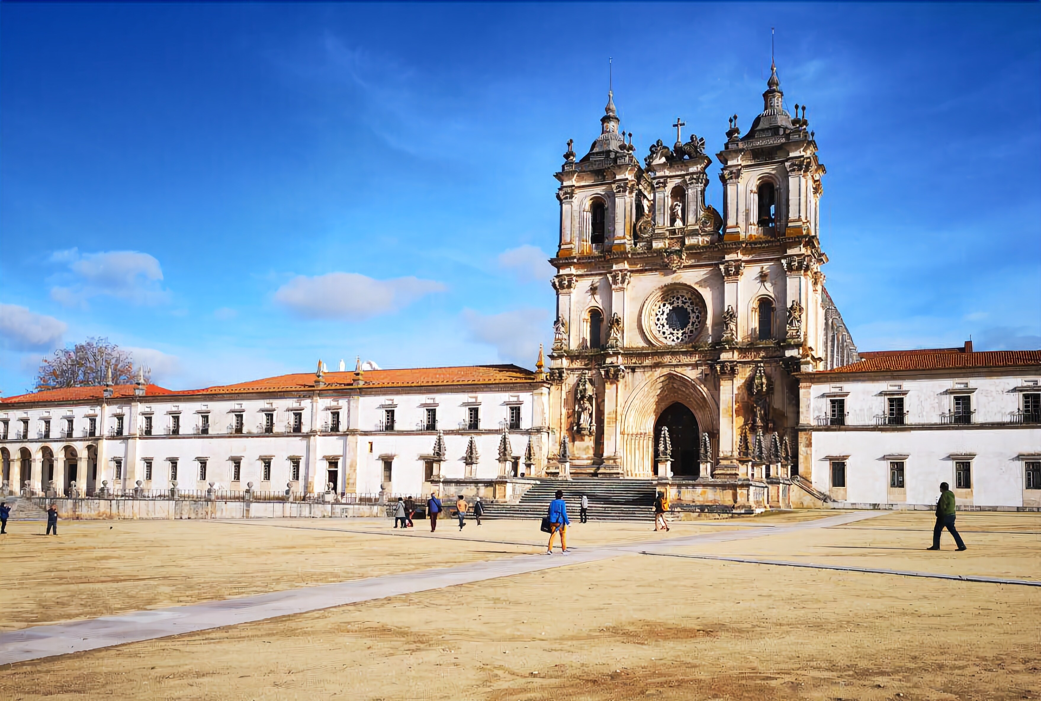 Un edificio grande e histórico con una cúpula central y múltiples torres, rodeado de un patio espacioso.