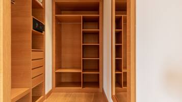 A walk-in closet with multiple wooden shelves and drawers.