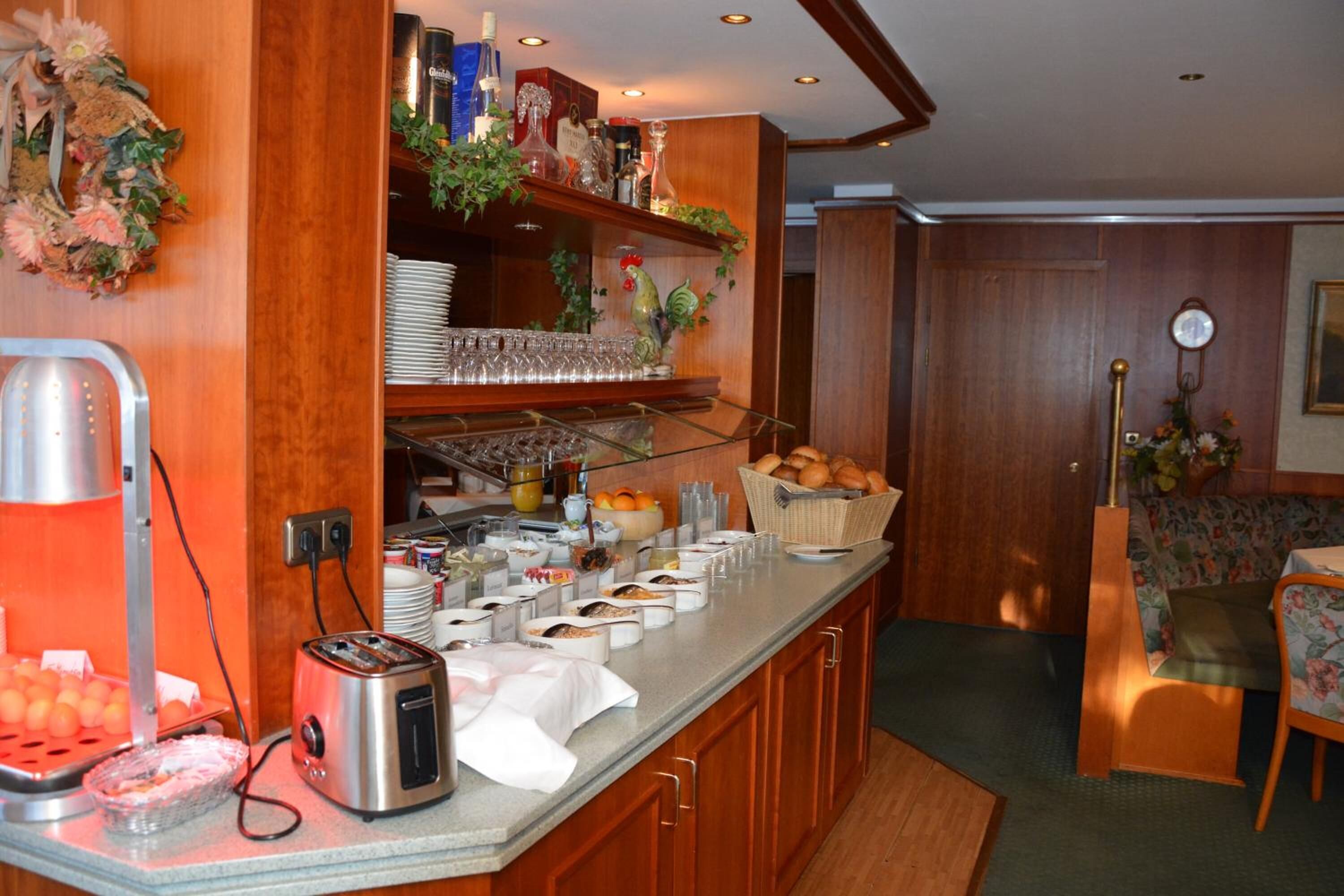 Una barra de desayuno con diversas opciones de alimentos, un tostador y una cafetera.