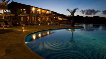 Relax by the pool surrounded by lounge chairs and umbrellas.