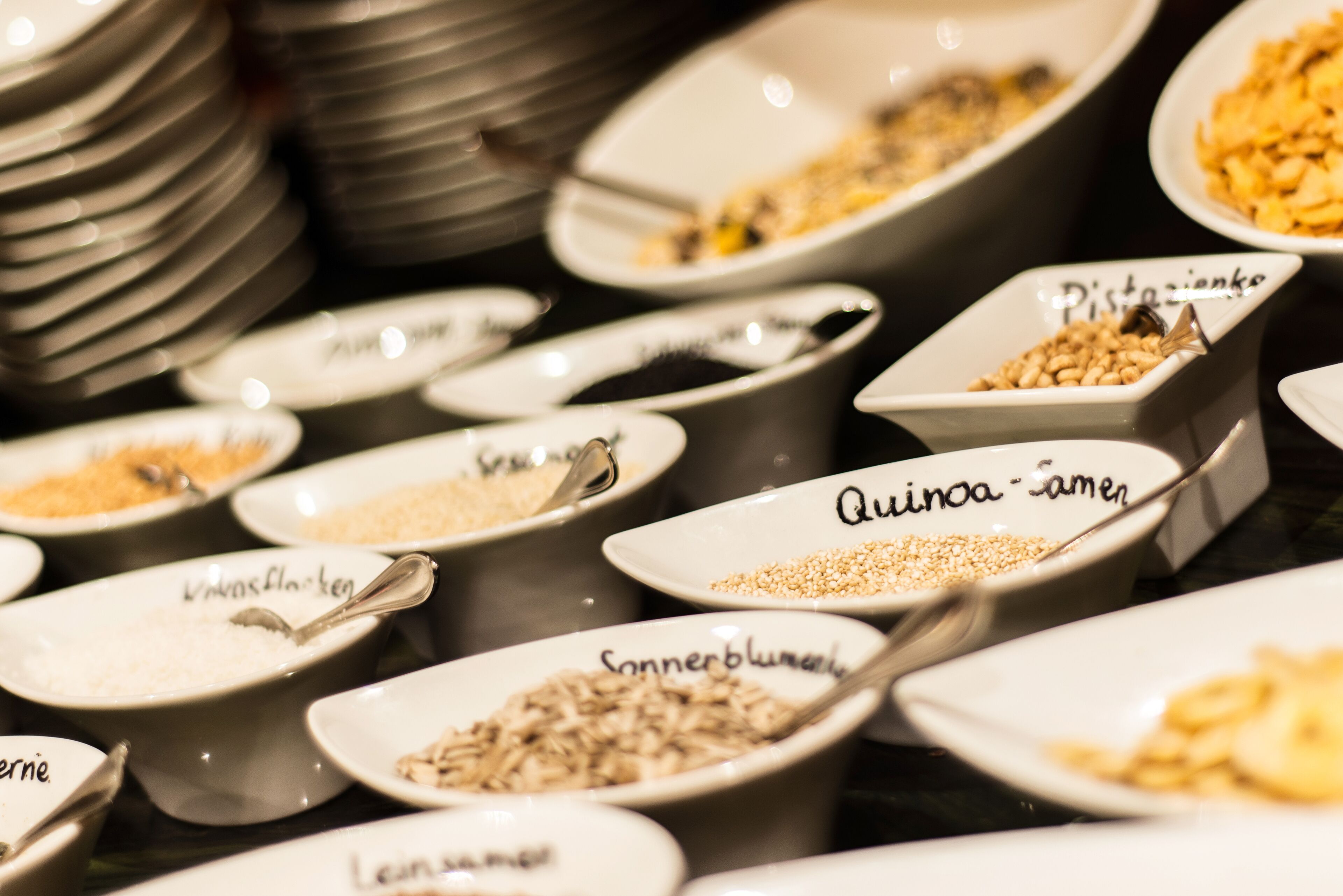 A variety of food items in bowls with labels, including quinoa and lentils.